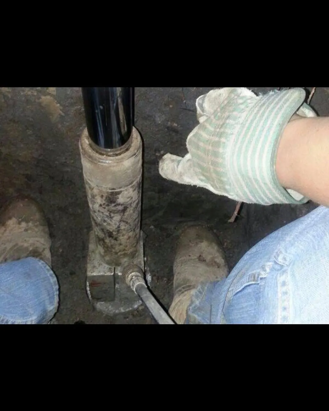 Hydraulic cylinder in use beneath a residential structure during lifting work